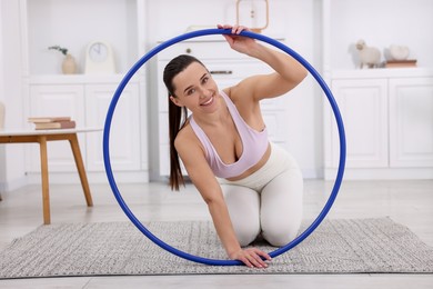 Photo of Smiling woman with hula hoop at home