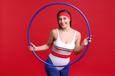 Photo of Smiling woman with hula hoop on red background