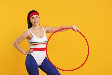 Photo of Smiling woman with hula hoop on orange background