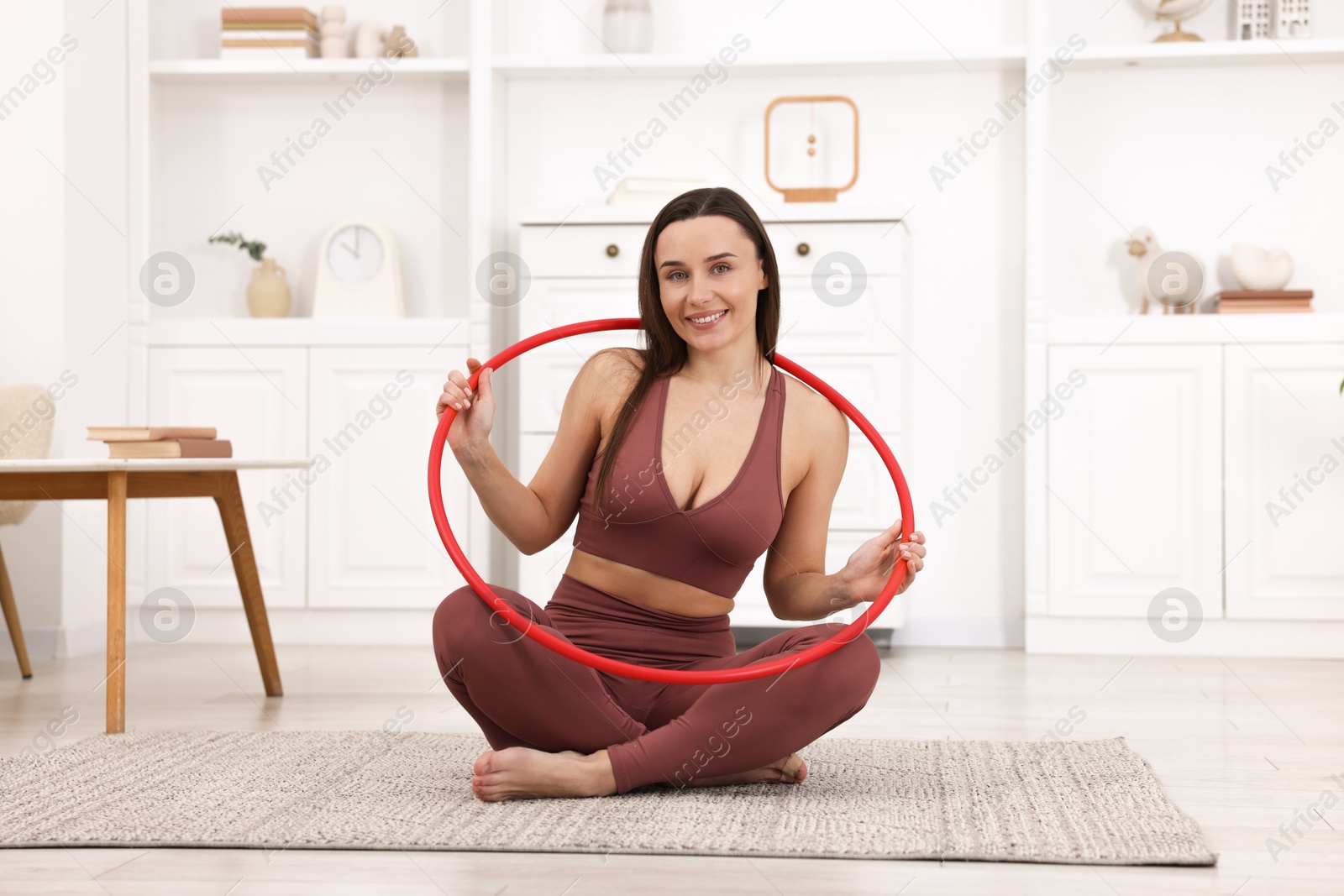 Photo of Smiling woman with hula hoop at home