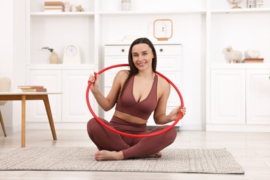 Photo of Smiling woman with hula hoop at home