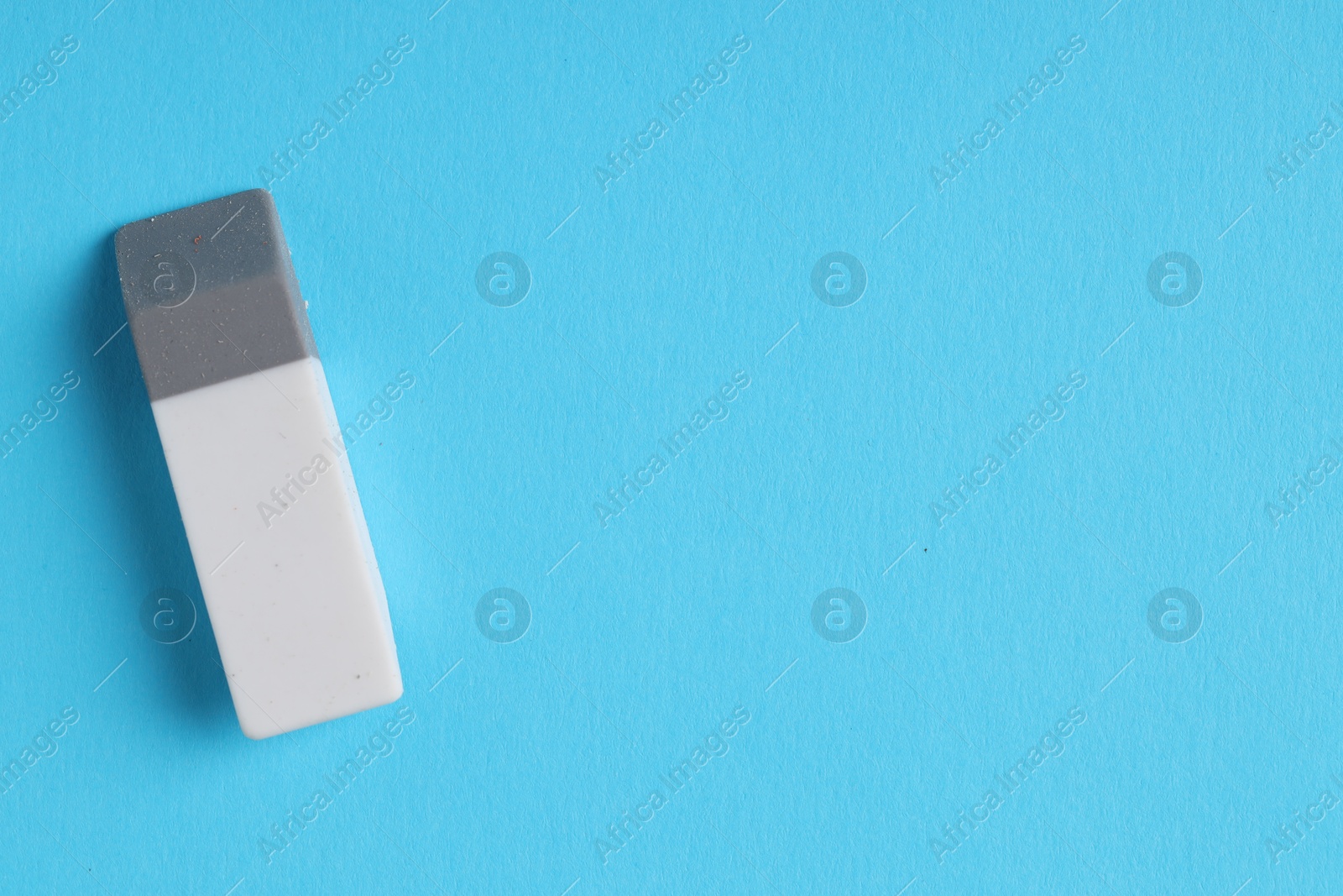 Photo of One eraser on light blue background, top view. Space for text