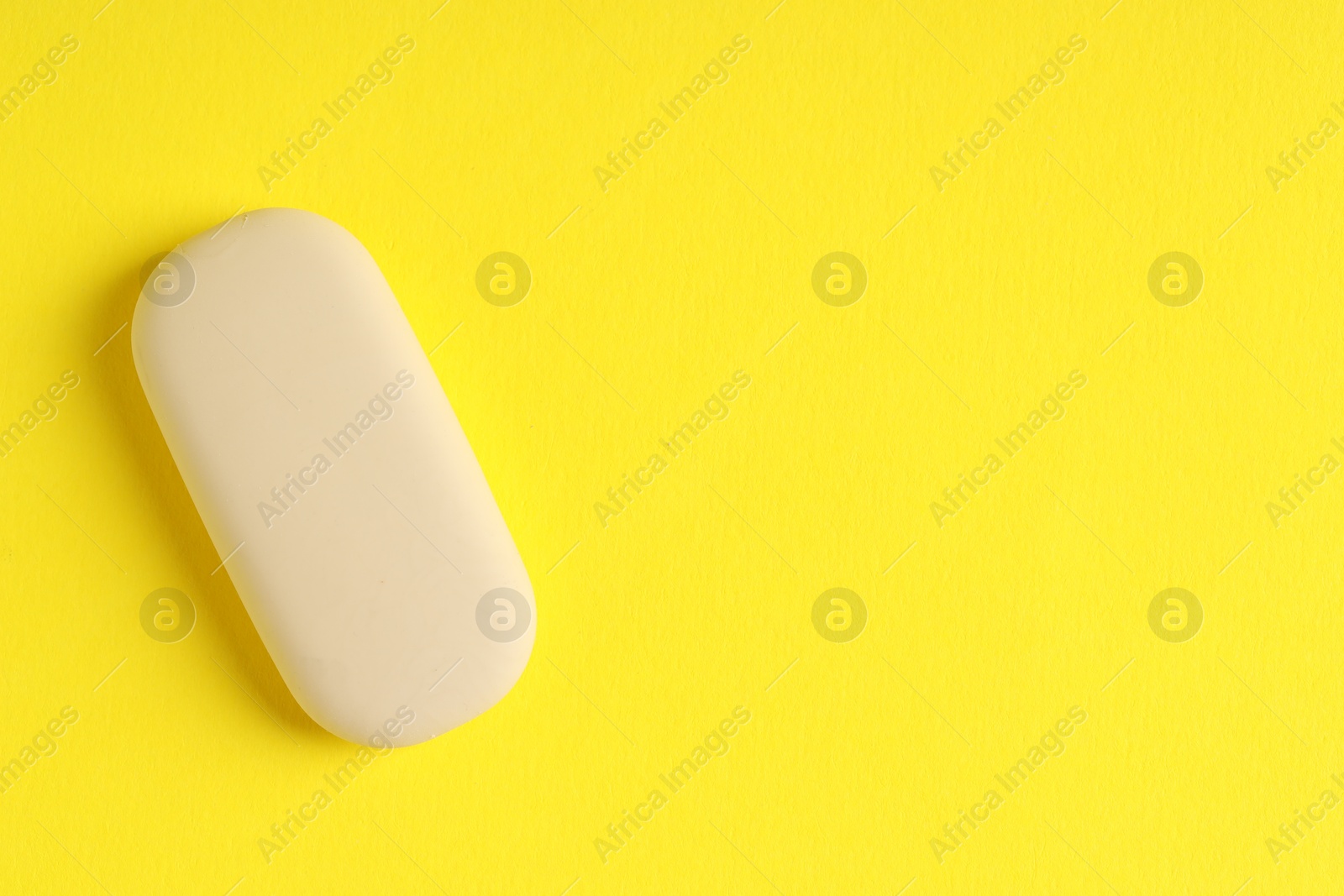 Photo of One eraser on yellow background, top view. Space for text