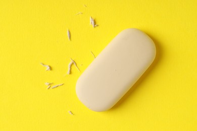 Photo of One eraser and scraps on yellow background, top view