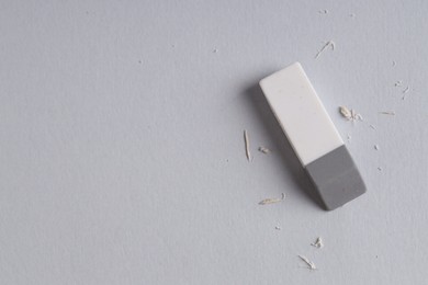 Photo of One eraser and scraps on grey background, top view. Space for text