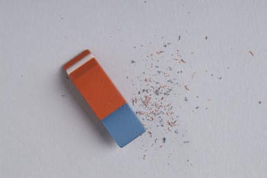 Photo of One eraser and scraps on grey background, top view