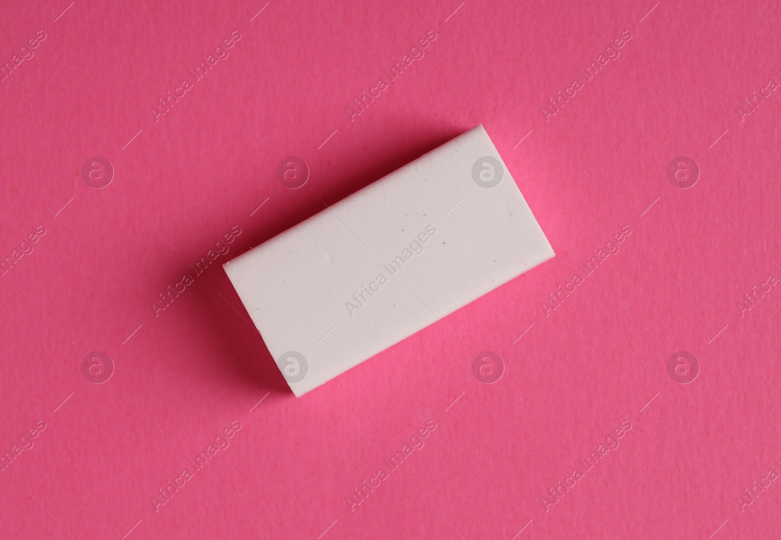 Photo of One eraser on pink background, top view