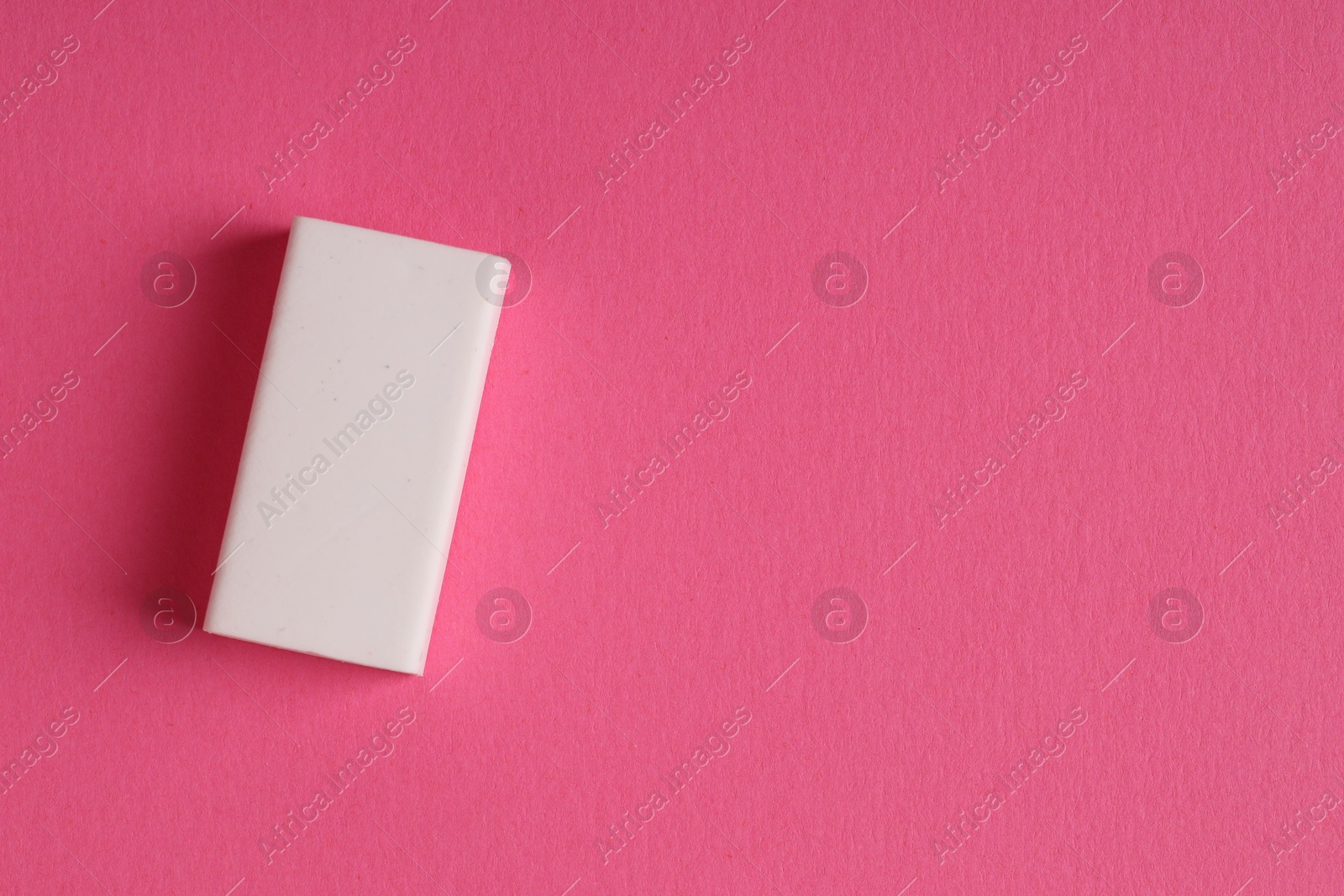 Photo of One eraser on pink background, top view. Space for text