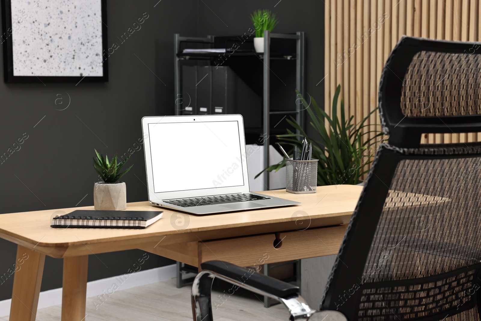 Photo of Comfortable workplace with modern laptop on wooden table indoors