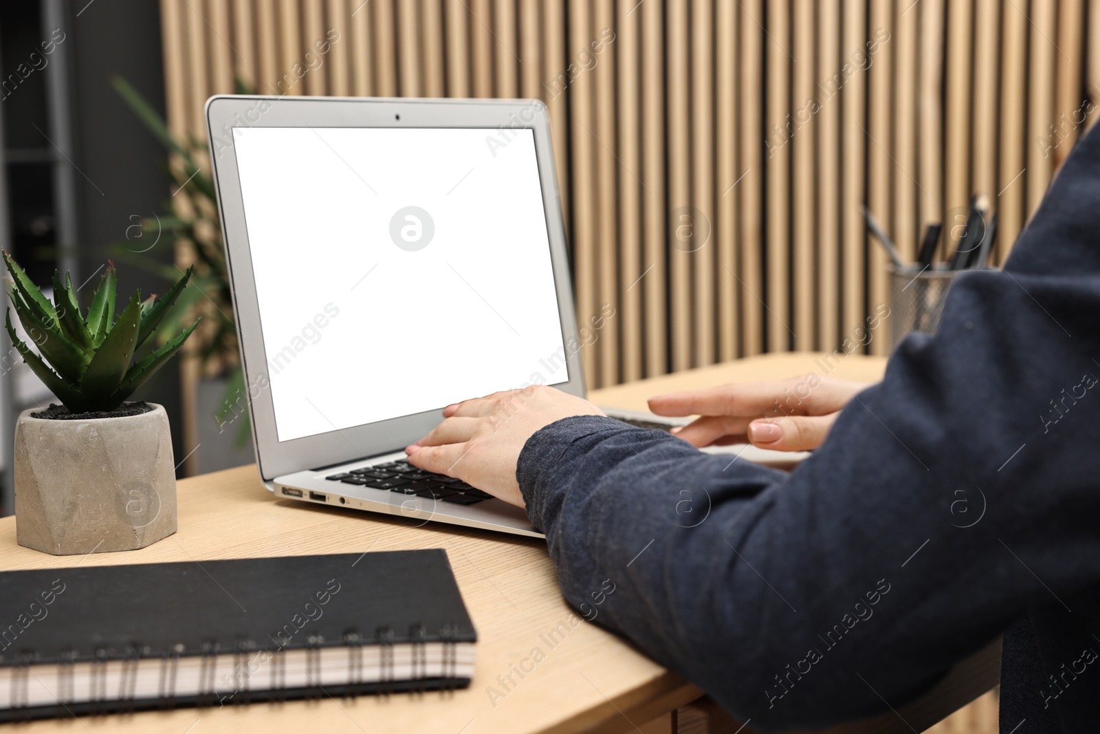 Photo of Woman working on computer at desk indoors, closeup