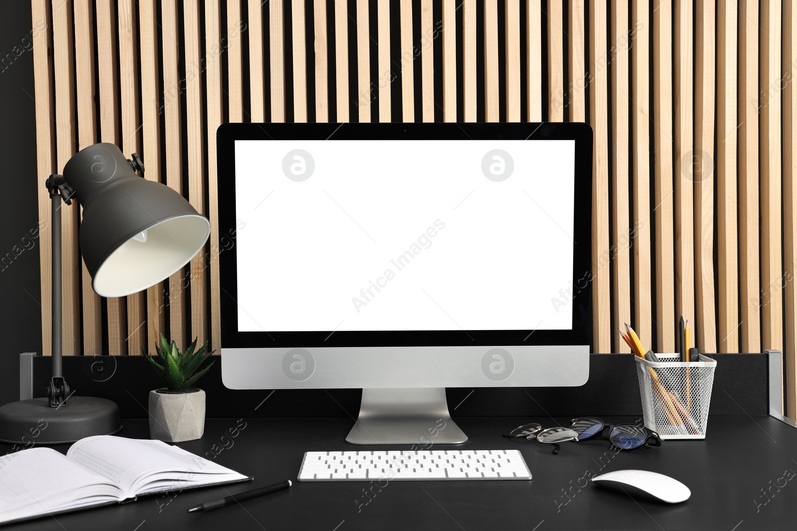 Photo of Comfortable workplace with modern computer on black table indoors