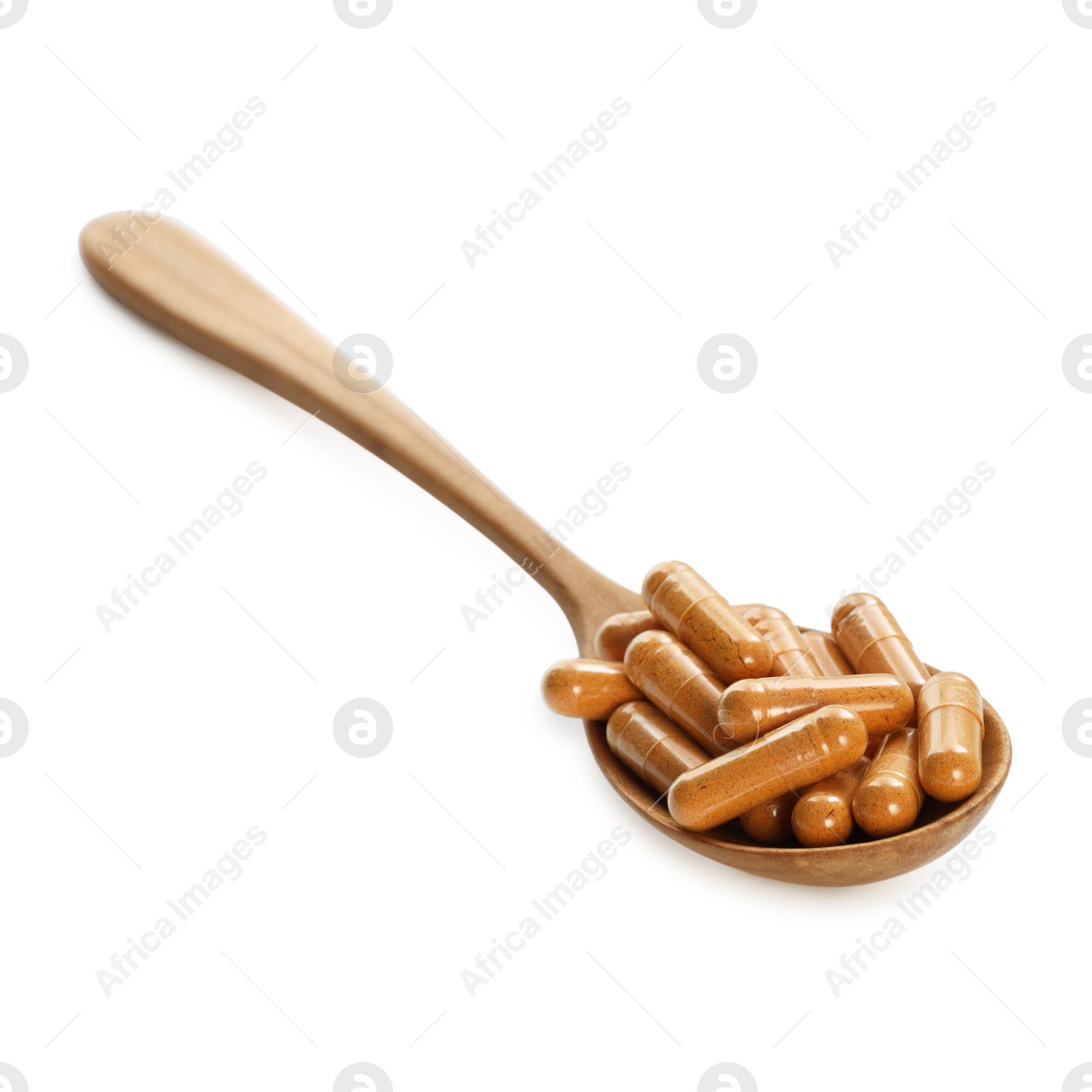 Photo of Turmeric capsules in spoon isolated on white