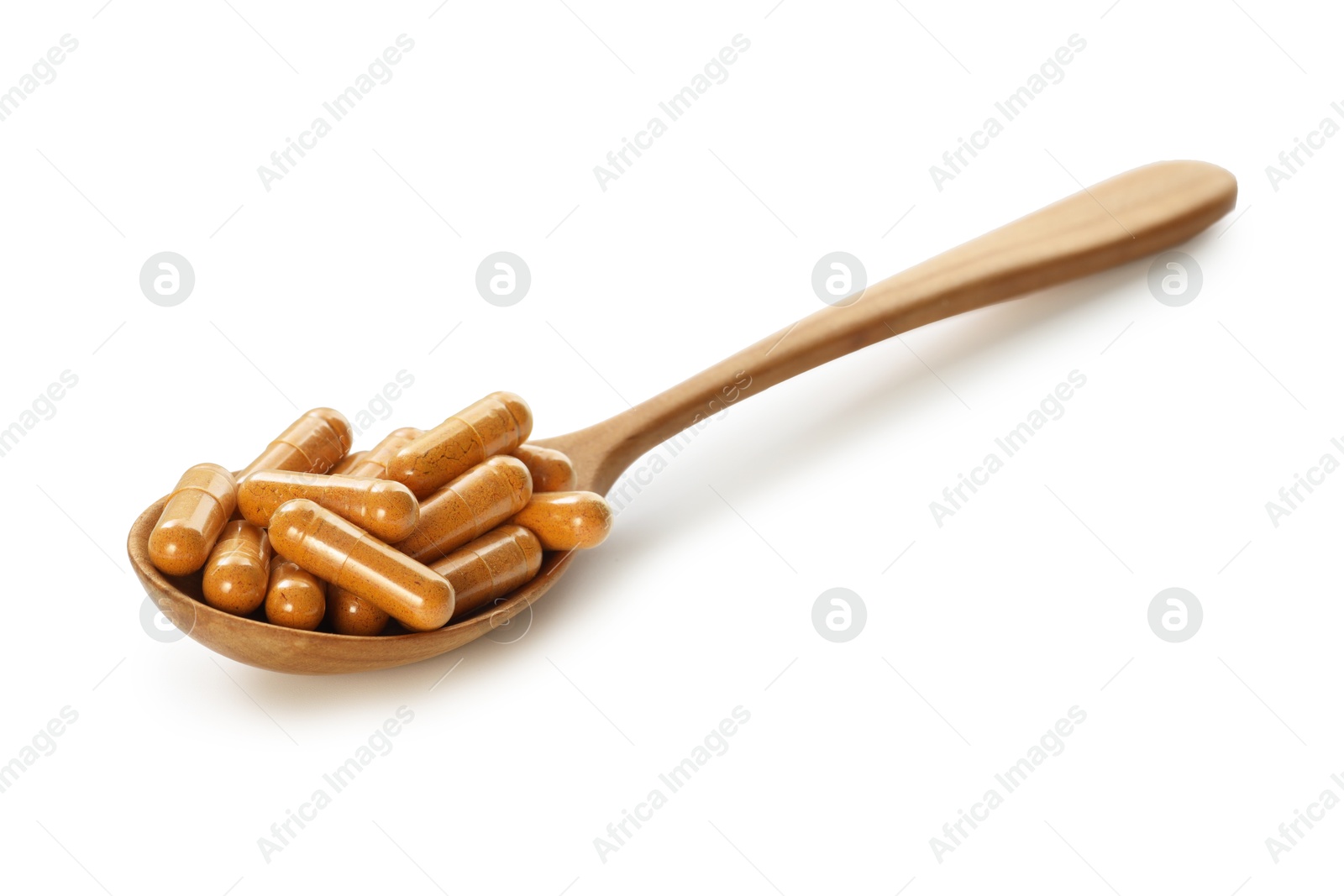 Photo of Turmeric capsules in spoon isolated on white