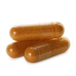 Photo of Three turmeric capsules isolated on white. Herbal dietary supplement