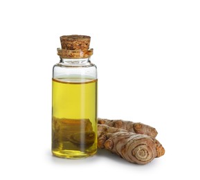 Photo of Bottle of turmeric essential oil and raw roots isolated on white