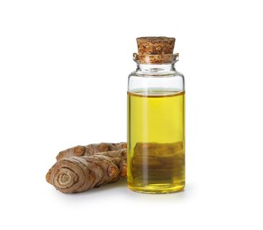 Photo of Bottle of turmeric essential oil and raw roots isolated on white