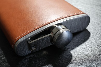 Photo of One hip flask on black table, closeup