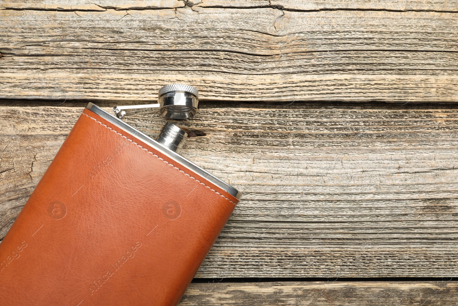 Photo of One hip flask on wooden table, top view. Space for text