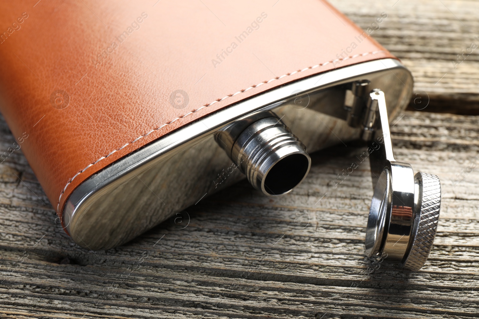 Photo of One hip flask on wooden table, closeup