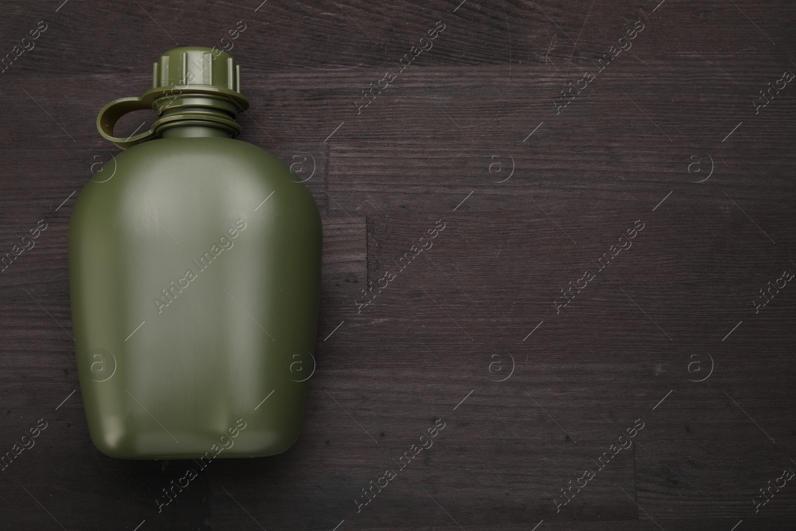 Photo of Green plastic canteen on wooden table, top view. Space for text