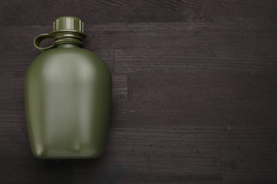 Photo of Green plastic canteen on wooden table, top view. Space for text