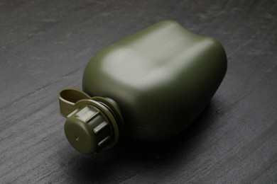 Green plastic canteen on black table, closeup