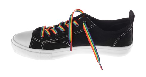 Photo of Black shoe with bright rainbow lace on white background. LGBT concept