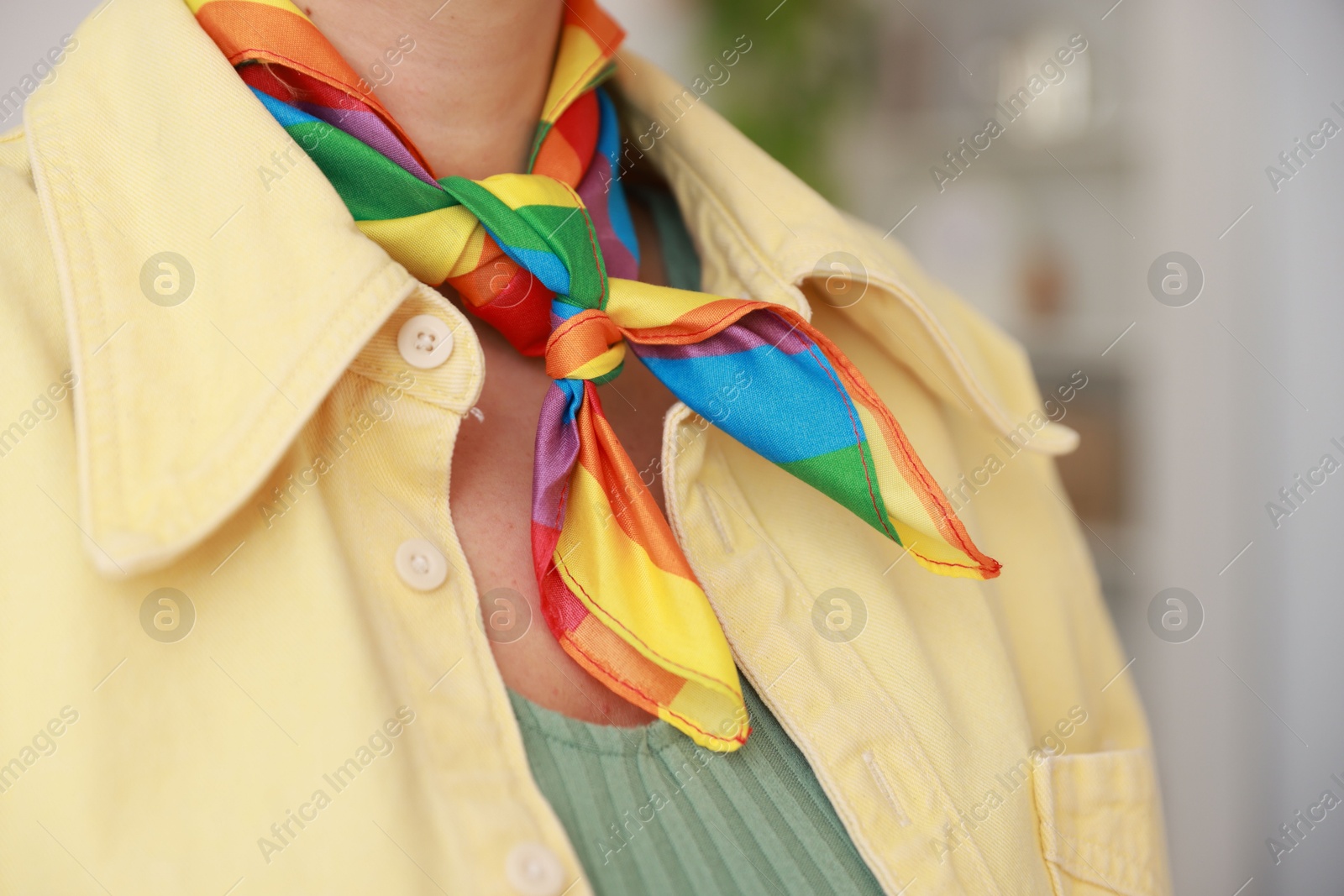 Photo of Woman wearing neckerchief in LGBT colors indoors, closeup