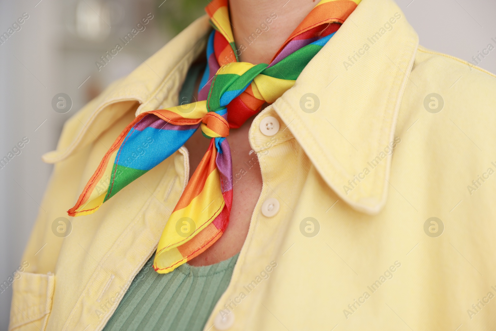 Photo of Woman wearing neckerchief in LGBT colors indoors, closeup