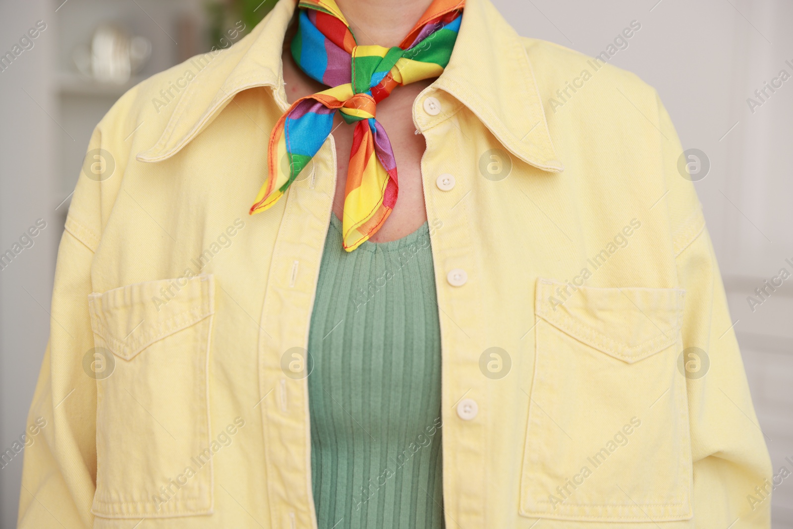 Photo of Woman wearing neckerchief in LGBT colors indoors, closeup