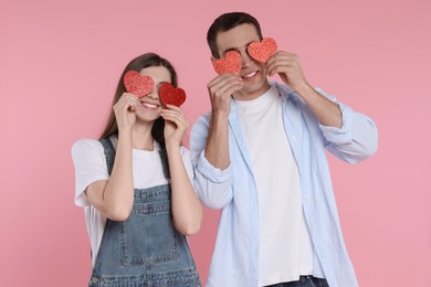 Photo of Lovely couple with paper hearts on pink background. Valentine's day celebration