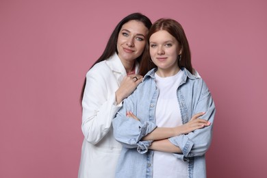 Photo of Family portrait of beautiful mother with teenage daughter on pink background