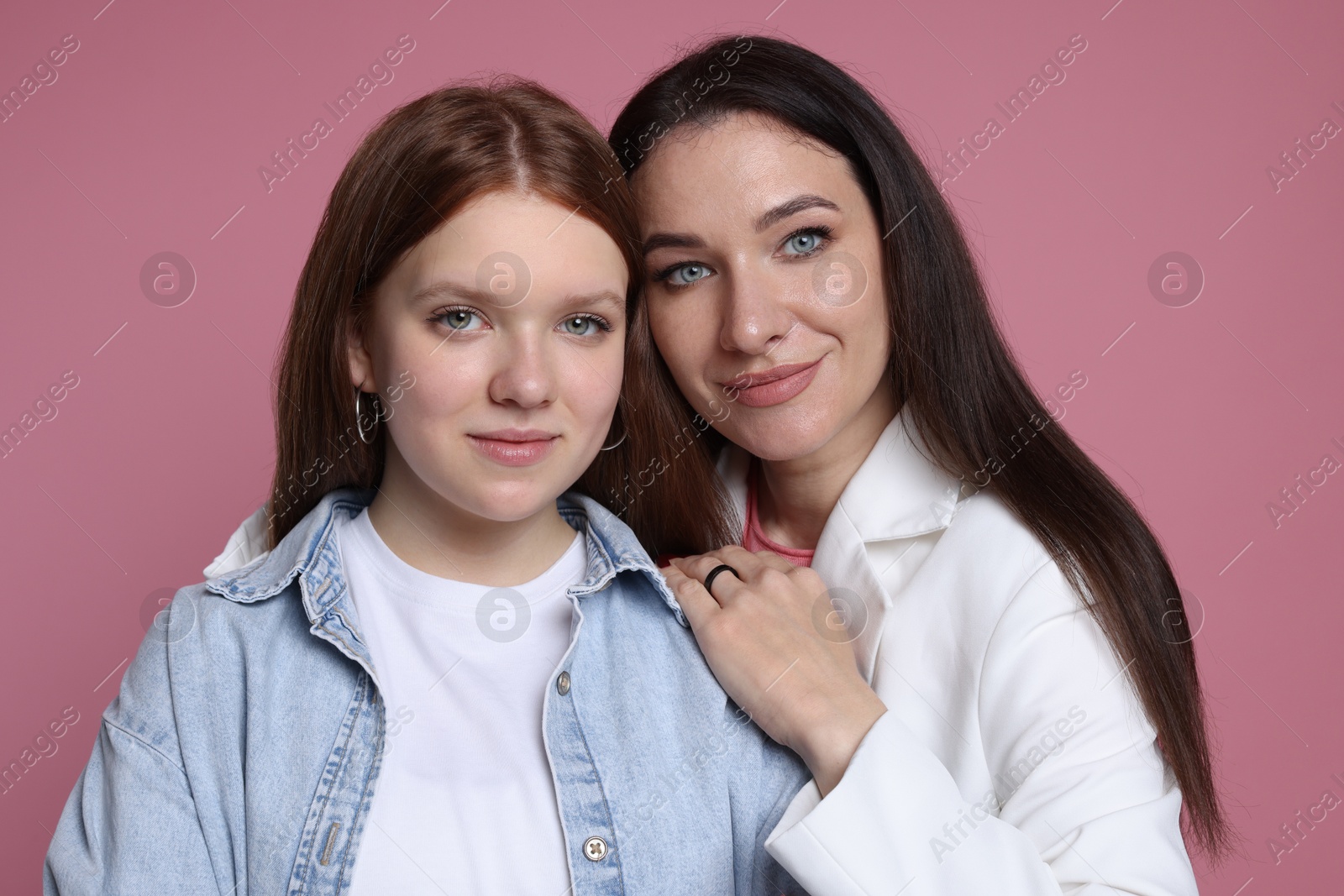 Photo of Family portrait of beautiful mother with teenage daughter on pink background