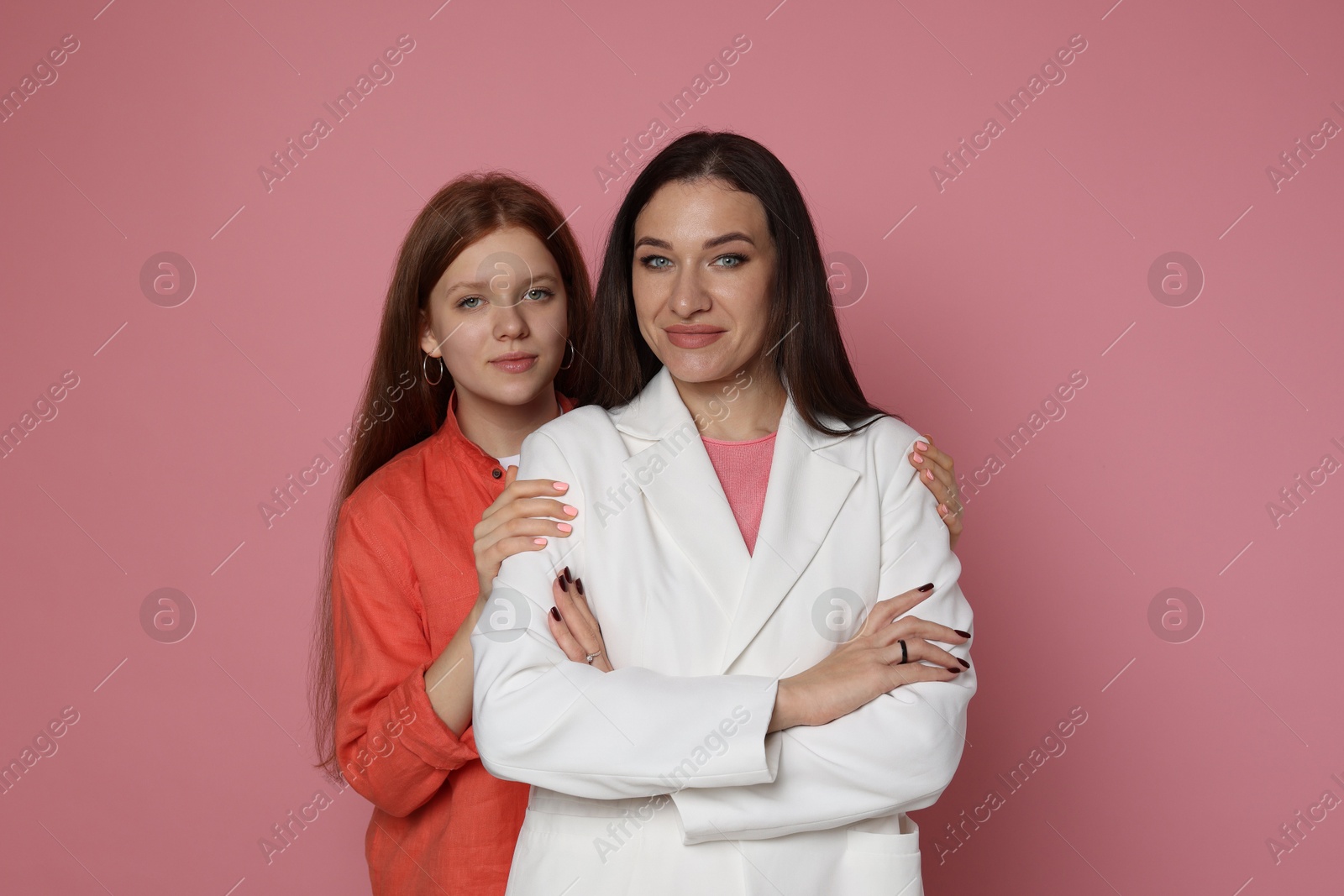 Photo of Family portrait of beautiful mother with teenage daughter on pink background