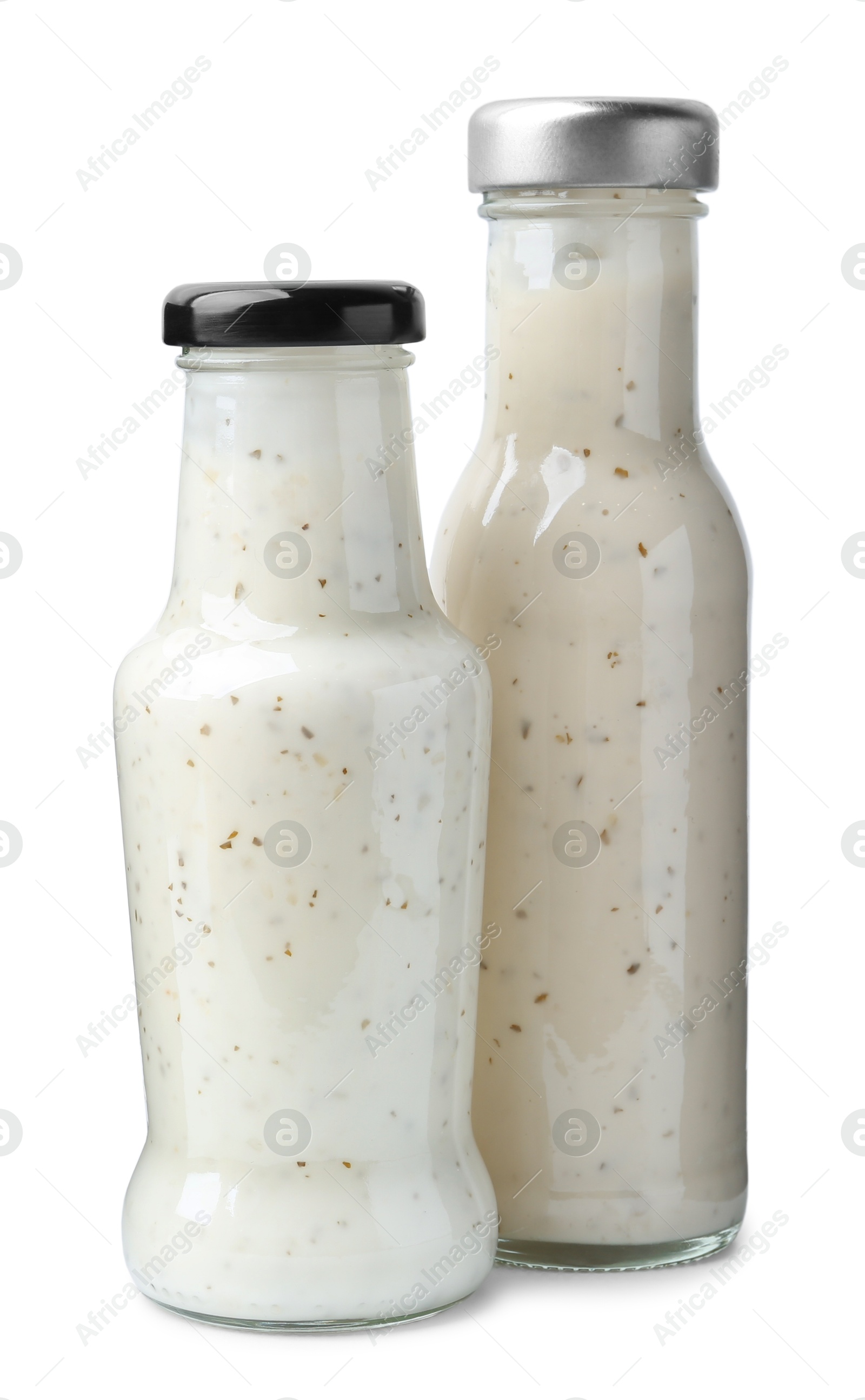 Photo of Different delicious sauces in glass bottles isolated on white