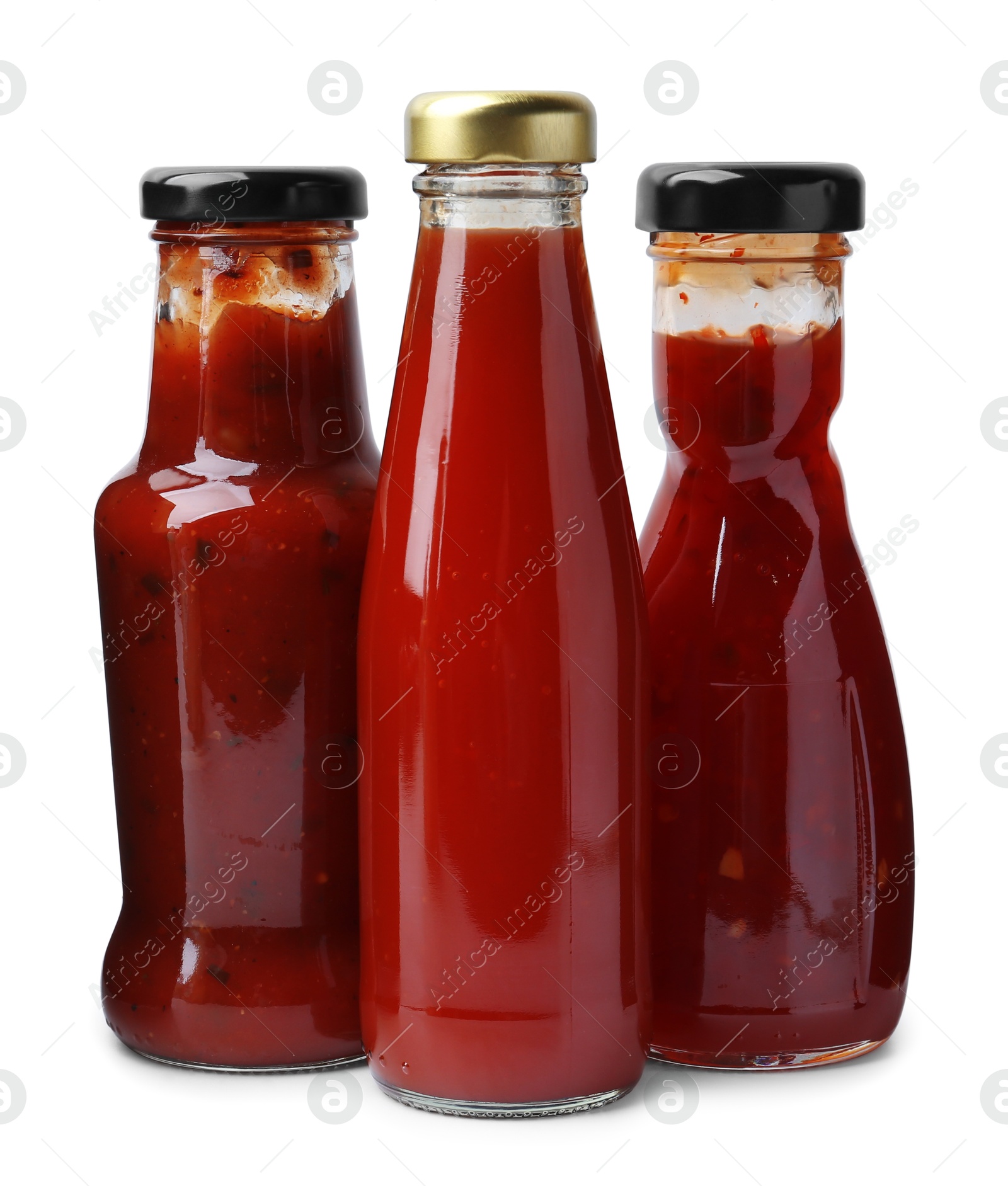 Photo of Different delicious sauces in glass bottles isolated on white