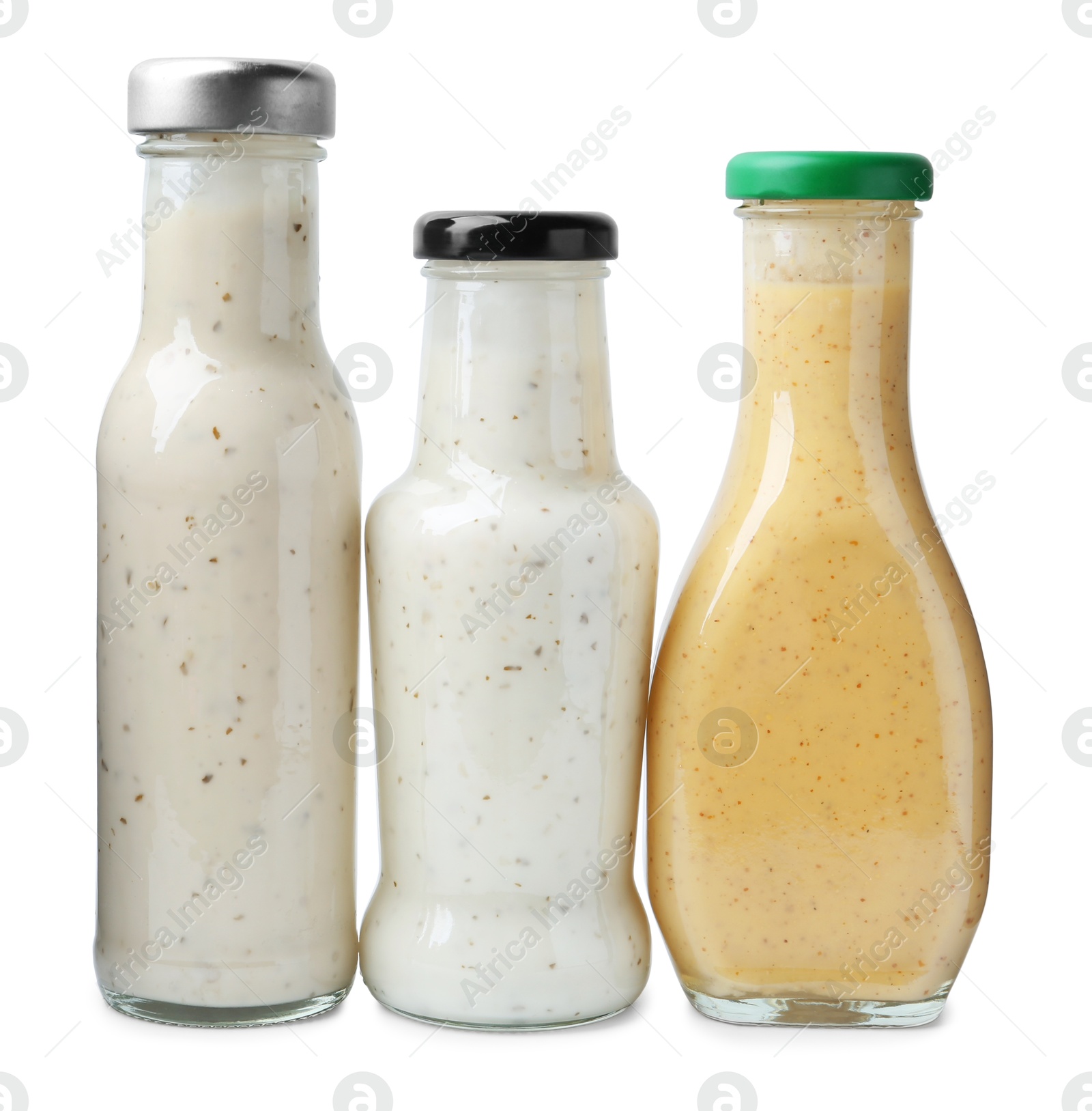 Photo of Different delicious sauces in glass bottles isolated on white