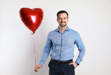 Photo of Happy Valentine's Day. Man with heart shaped balloon on white background