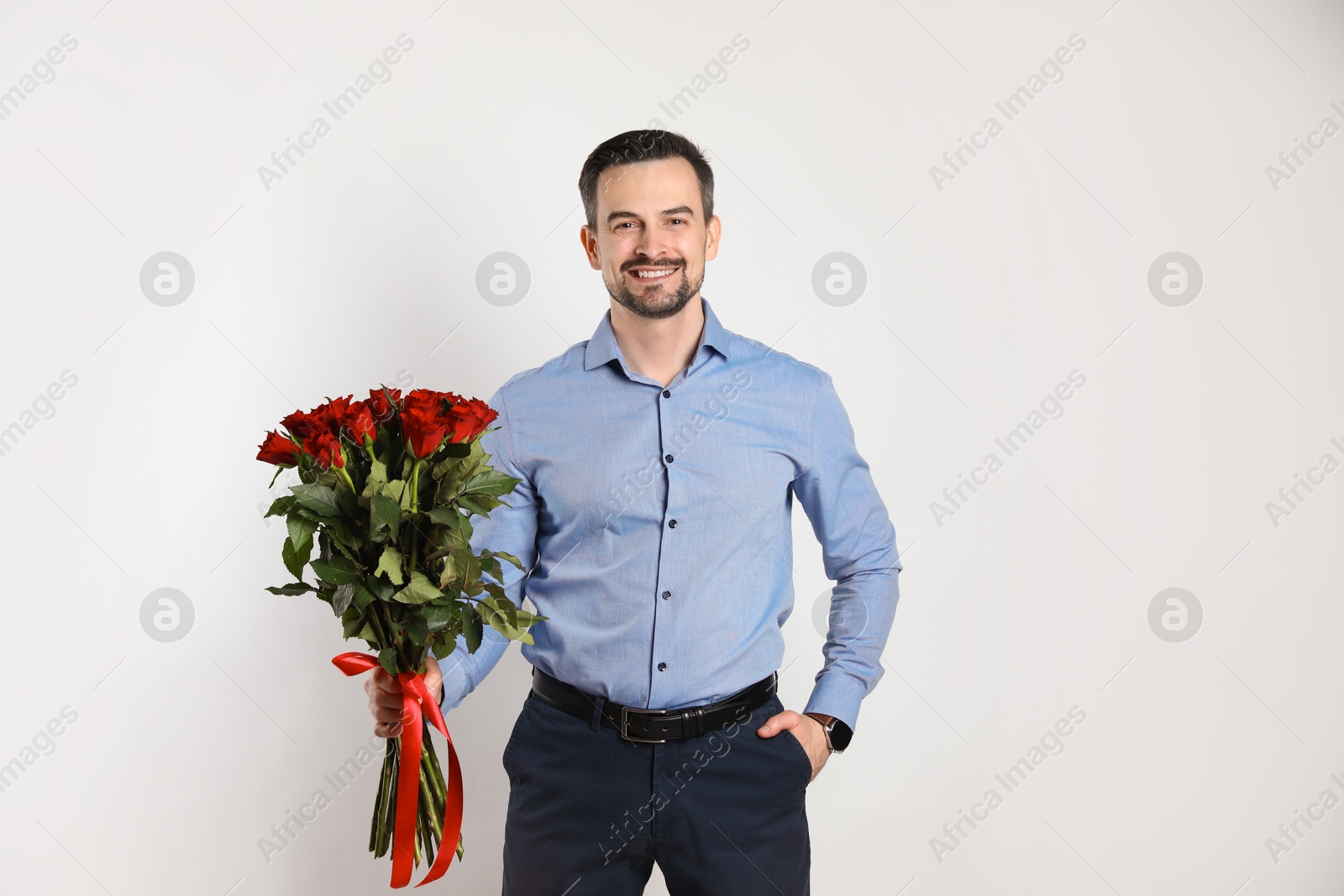 Photo of Happy Valentine's Day. Handsome man with bouquet of roses on white background