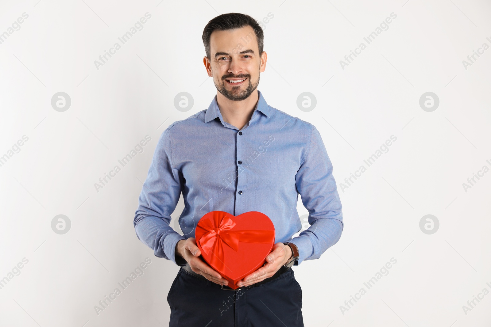 Photo of Happy Valentine's Day. Handsome man with heart shaped gift box on white background