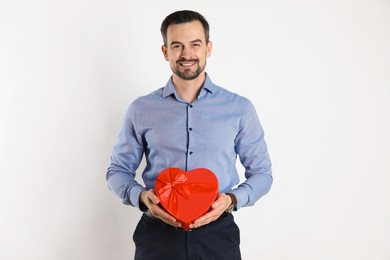 Photo of Happy Valentine's Day. Handsome man with heart shaped gift box on white background