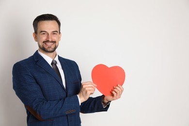 Photo of Happy Valentine's Day. Handsome man with paper heart on white background. Space for text