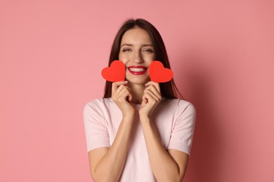 Photo of Happy Valentine's Day. Beautiful woman with paper hearts on pink background