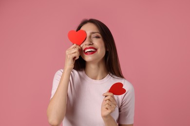 Photo of Happy Valentine's Day. Beautiful woman with paper hearts on pink background