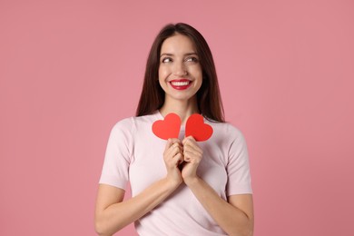 Photo of Happy Valentine's Day. Beautiful woman with paper hearts on pink background