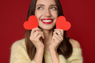 Photo of Happy Valentine's Day. Beautiful woman with paper hearts on red background