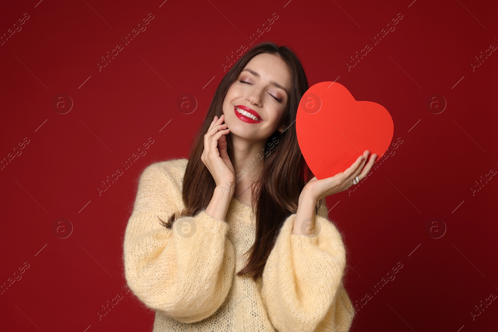 Photo of Happy Valentine's Day. Beautiful woman with paper heart on red background