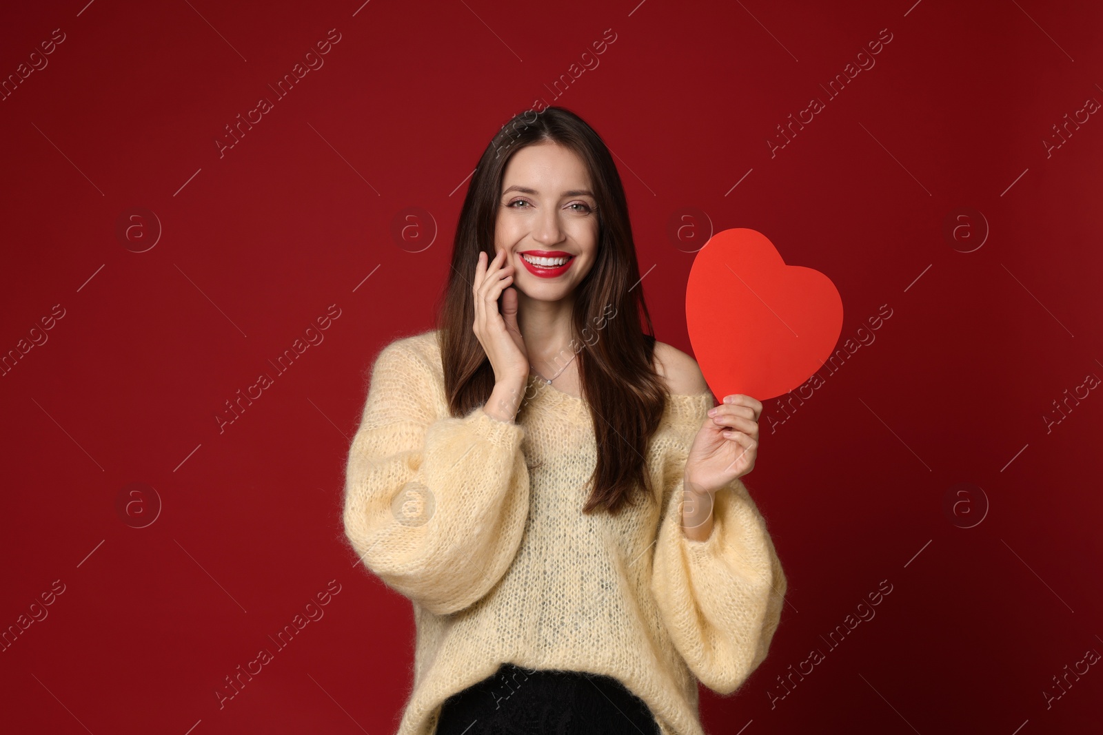 Photo of Happy Valentine's Day. Beautiful woman with paper heart on red background