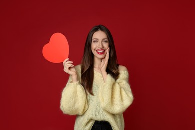 Photo of Happy Valentine's Day. Beautiful woman with paper heart on red background