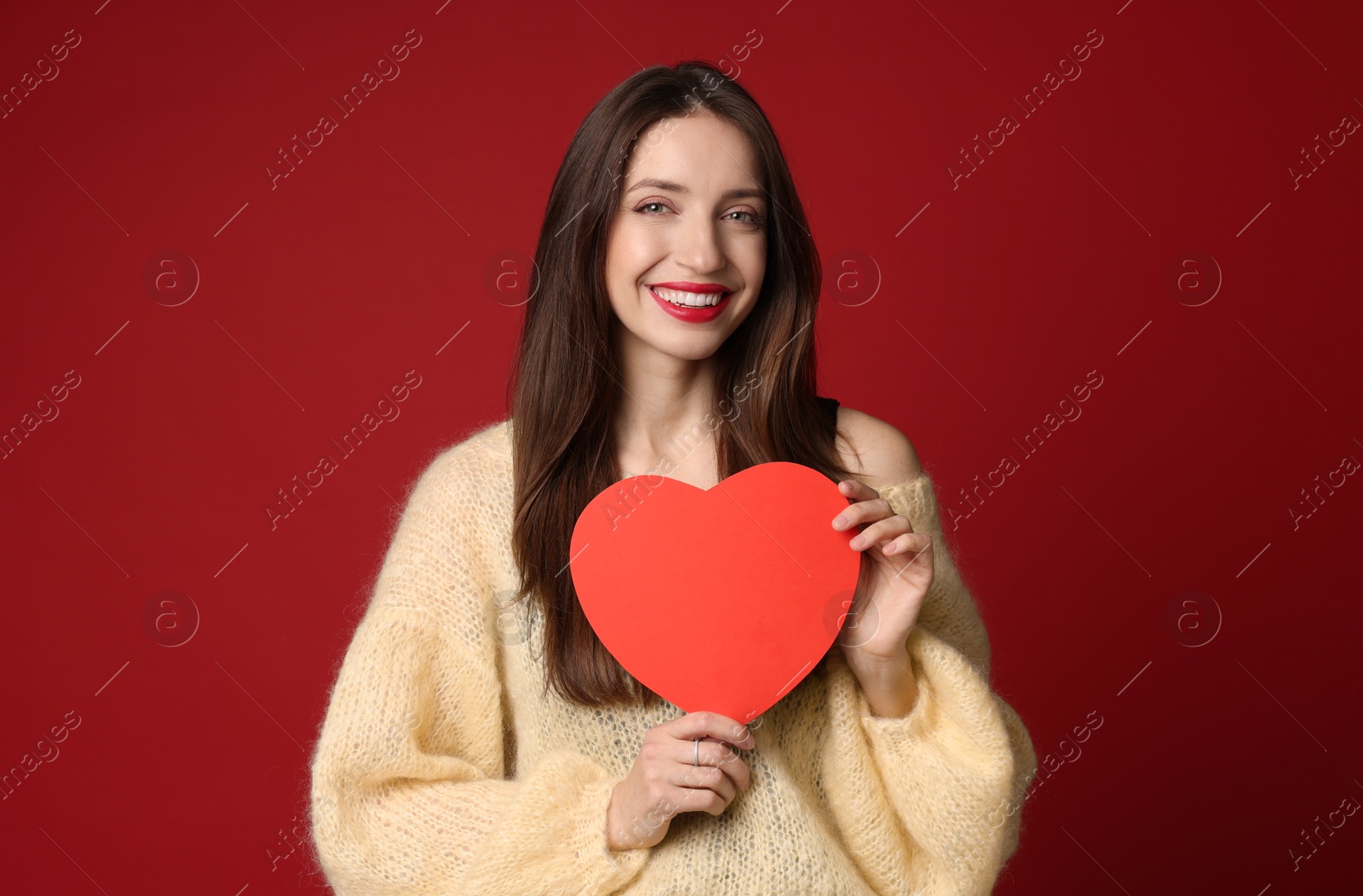 Photo of Happy Valentine's Day. Beautiful woman with paper heart on red background